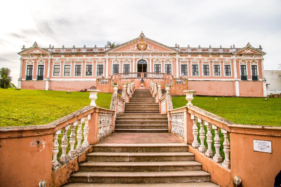 Fachada da Sociedade Portuguesa de Bagé com escadaria central e arquitetura clássica preservada, em foto atual do prédio histórico.